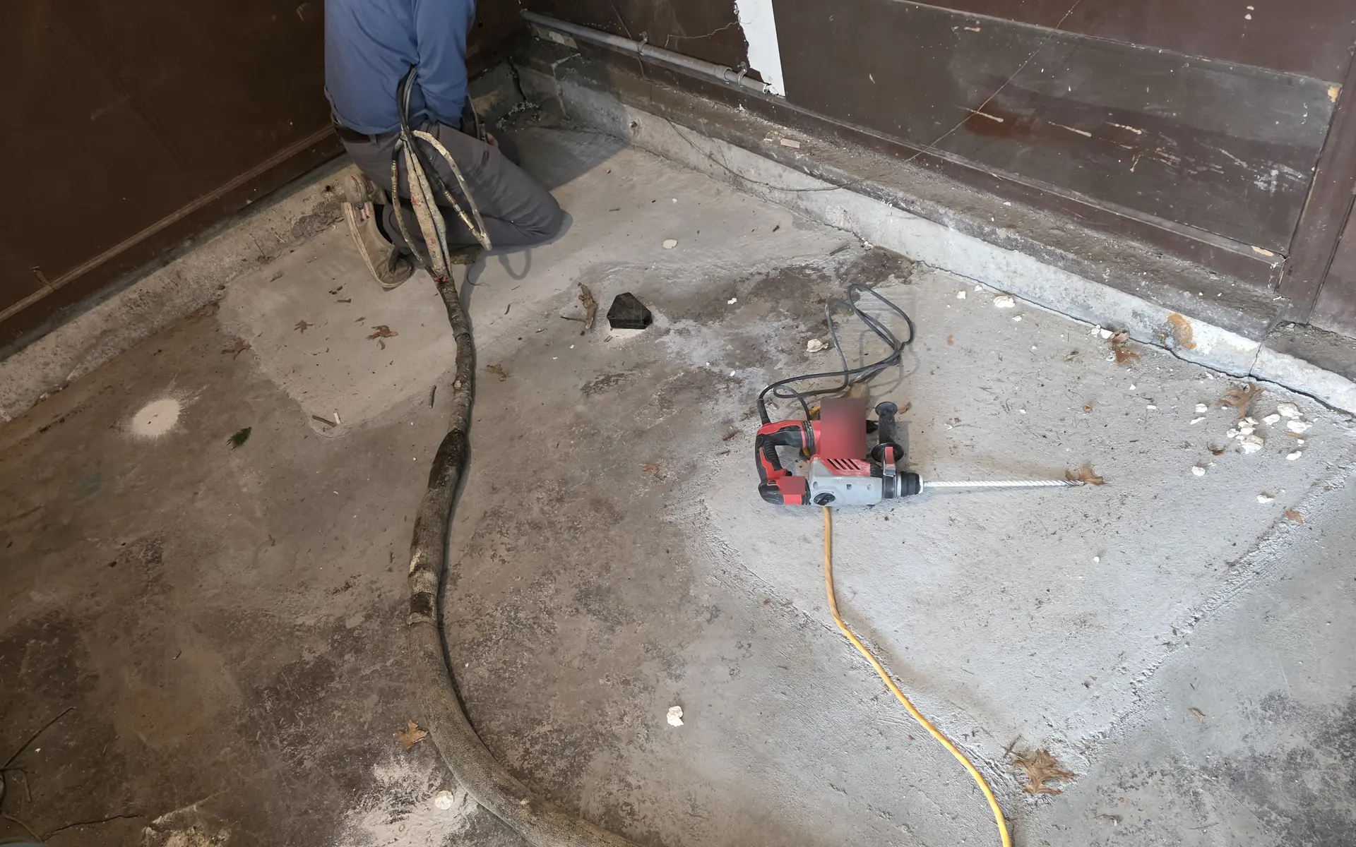 Drilling a small injection port into a concrete slab with a rotary hammer drill -- PolyJacks concrete leveling serving Spring Hill, KS.