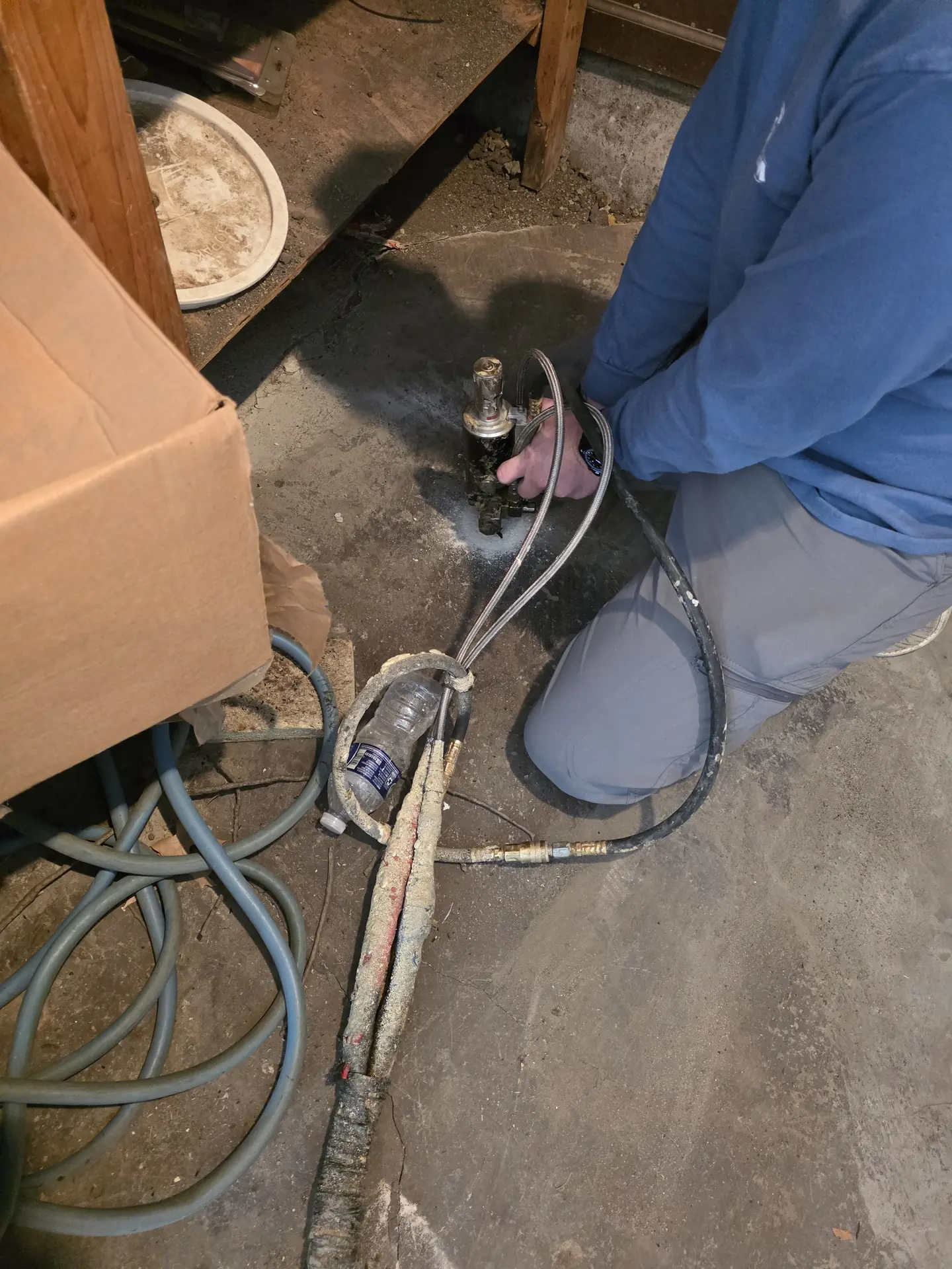 Polyurethane foam injection equipment and hoses on a concrete floor -- PolyJacks concrete leveling serving Kansas City, MO.